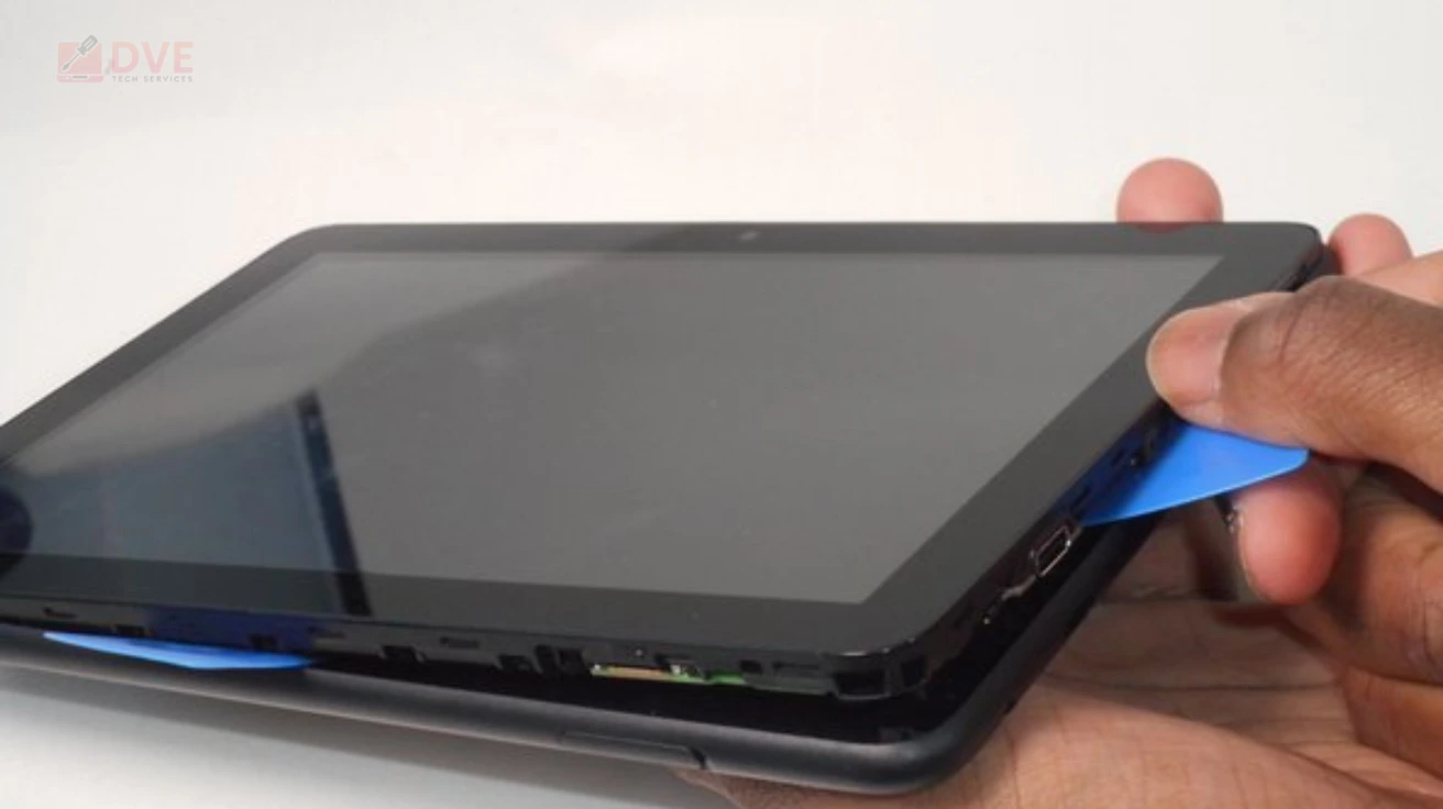 Close-up of a damaged tablet being opened for amazon fire tablet repair, showing battery cover separation and internal access preparation
